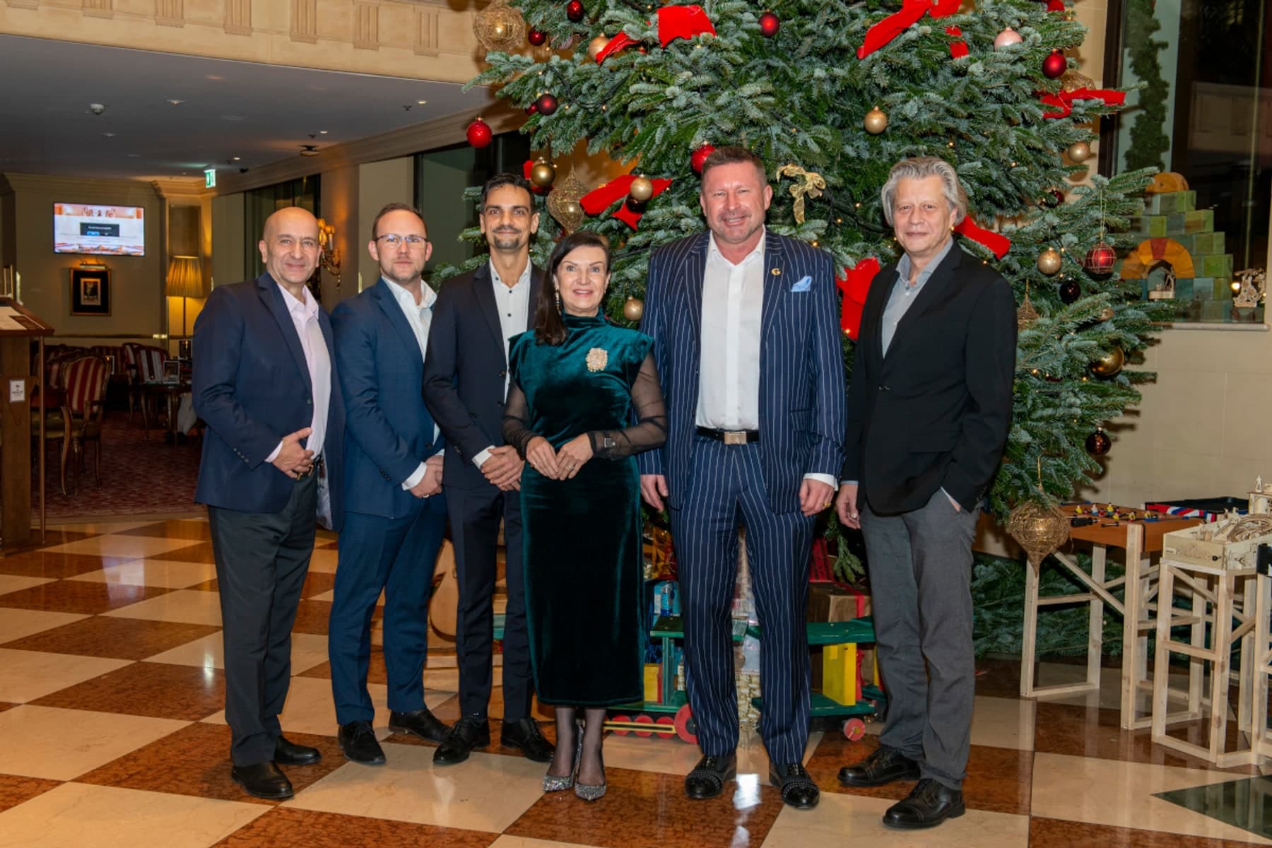 Ramin Monajemi, Robert Ziegenfelder, Marc Zoll, Herta Habsburg, Thomas Schröck und Robert Gillinger vor dem Weihnachtsbaum im Grand Hotel Wien